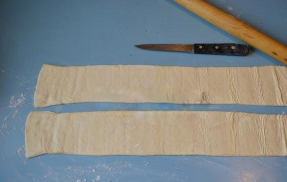 1. Этап. Слоеный пирог с сыром и зеленью: Разрежьте листы готового теста на полосы шириной около 10 см. (при необходимости немного раскатайте тесто при помощи скалки).