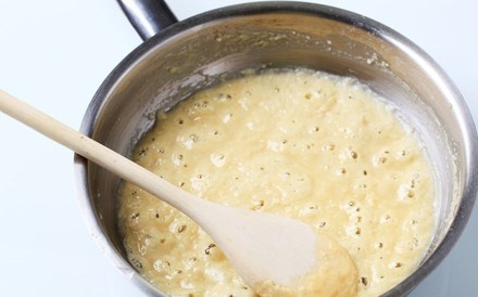 1. Этап. Постная пицца с грибами: 4. Тем временем можно заняться соусом. Постная пицца с грибами в домашних условиях может быть сделана с томатным соусом или таким интересным вариантом соуса Бешамель. Итак, в небольшом сотейнике разогреть 1 ложку растительного масла и всыпать туда муку. Тщательно помешивая, чтобы не образовались комочки, поджарить немного. Тонкой струйкой влить горячий бульон, продолжая перемешивать, и добавить пропущенный через пресс чеснок. Подсолить по вкусу и можно снять с огня, чтобы дать ему остыть.