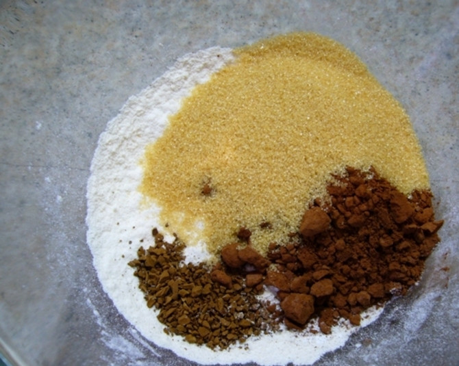 1. Этап. Кофейный кекс в микроволновке: Просейте муку в миску. Добавьте к ней какао, сахар, разрыхлитель, кофе, ванильный сахар.