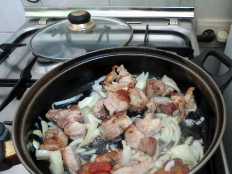 1. Этап. Опята со свининой: Отправьте мясо жариться на сковороду с растительным маслом. Тем временем лук порежьте полукольцами и отправьте его тоже в сковороду.