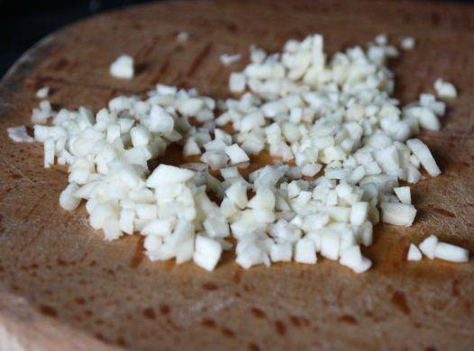 1. Этап. Салат из фасоли стручковой: Приготовьте соус. Для этого очистите и измельчите чеснок.