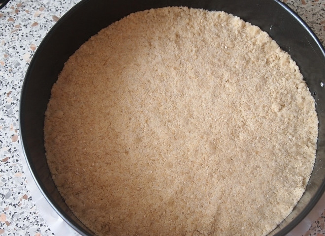 1. Этап. Творожно-маковый пирог: В форму для выпекания выложите пергаментную бумагу, смажьте ее растительным маслом. Потом утрамбуйте равномерно две трети крошки и отправьте форму в холодильник.