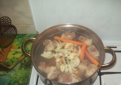 1. Этап. Бешбармак из говядины: Очищаем морковку и лук. Морковь разрезаем на несколько частей, луковицу надрезаем. Как только мясо закипит, снимаем пенку и добавляем в кастрюлю овощи. Закрываем кастрюлю крышкой, уменьшаем огонь и варим до готовности мяса. Примерно часа 2. В конце варки можно добавим соль и молотый перец.