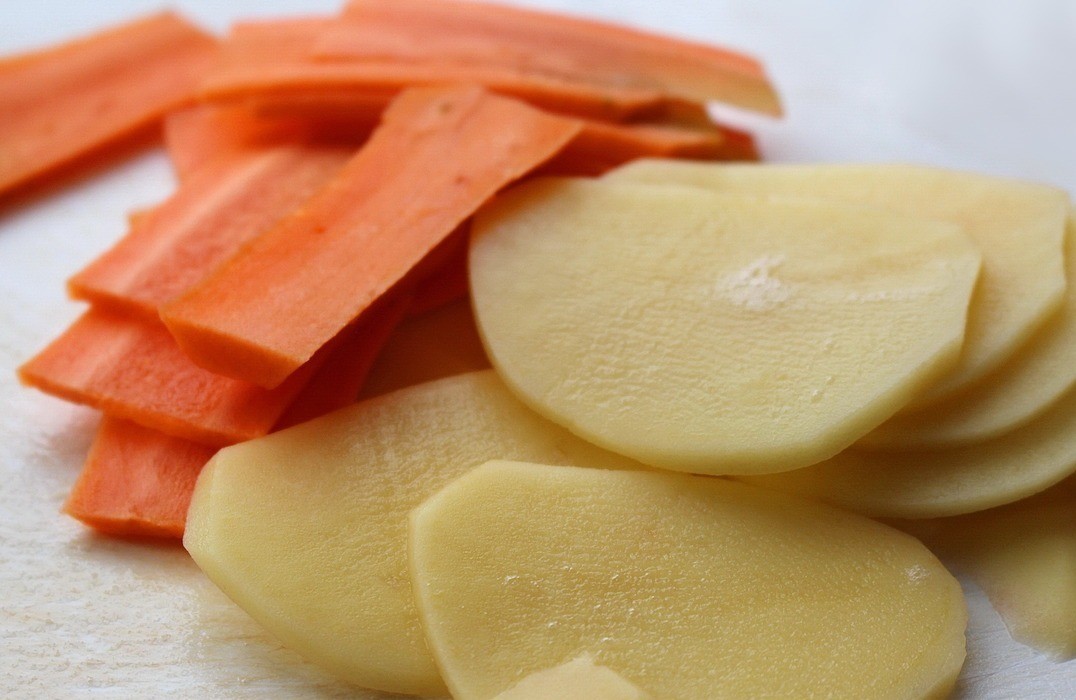 1. Stage. Herring in a fur coat in a new way: Make the chips. Peel potatoes and carrots and grate them on a mandolin.