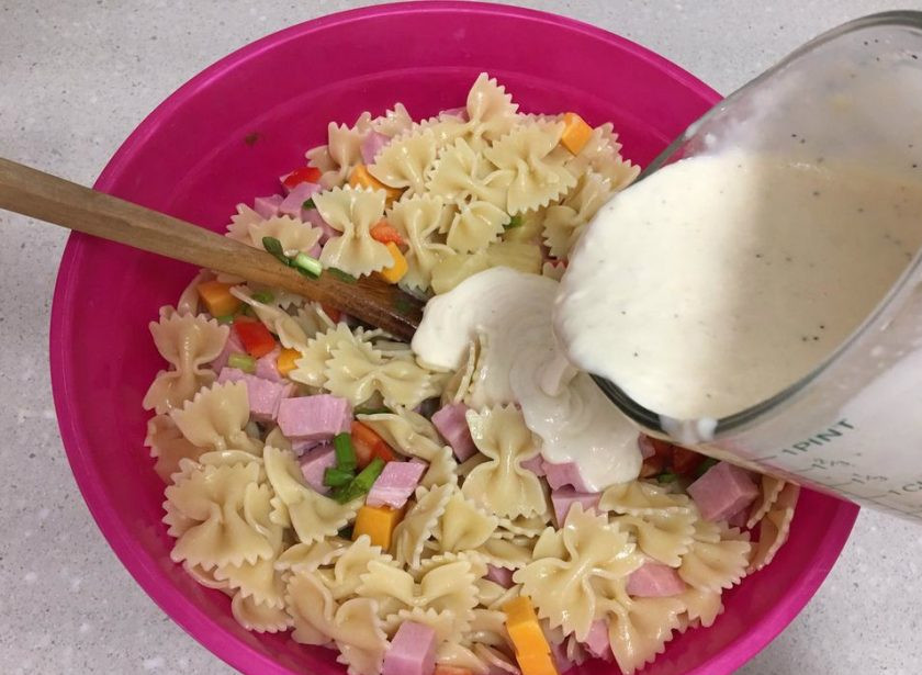 1. Этап. Салат с вареной колбасой: 8. Поливаю салат приготовленной ранее заправкой, после чего снова перемешиваю.