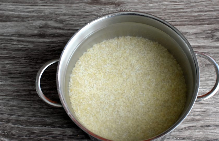 1. Этап. Рассольник с копченостями: Перловую крупу замочите на час, затем промойте, залейте свежей водой и варите почти до готовности. Слейте крупу на сито и промойте под холодной водой от слизи. Дайте крупе немного обсохнуть. Обычно я варю перловки побольше и излишки уже готовой крупы замораживаю. Это удобно и очень экономит время.