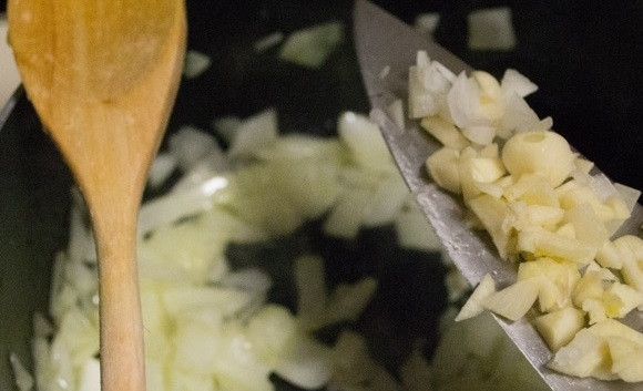 1. Этап. Домашний томатный соус для макарон: 2. Очистите чеснок, нарежьте мелко зубчики, добавьте их в кастрюлю к луку, перемешайте и готовьте пару минут.