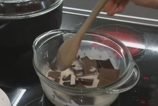 1. Этап. Настоящий торт Сникерс: 10. Для приготовления ганаша залейте сливки в кастрюлю и подогрейте, не доводя до кипения. Отправьте к ним поломанную плитку шоколада и оставьте в сторону, чтобы он растаял. Затем перемешайте миксером до однородной массы и дайте сливочному шоколаду постоять 30-50 минут.