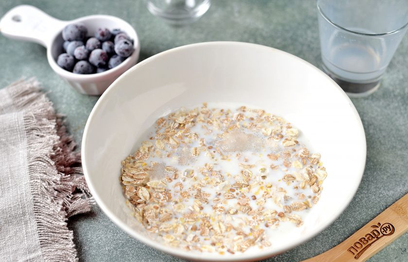 1. Этап. Каша Ассорти в микроволновке: Влейте стакан молока средней жирности, перемешайте хлопья.