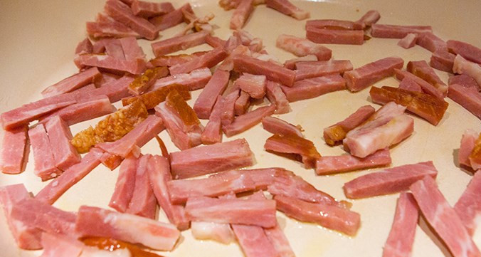 1. Этап. Спагетти под соусом Карбонара: Для начала поставьте воду для спагетти. Пока она будет закипать, приготовим соус. Порежьте кусочками бекон. На сковороде в оливковом масле обжарьте зубчики чеснока, потом уберите их. Выложите в то же масло бекон, чтобы обжарился.