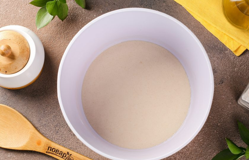 1. Этап. Пышные жареные пирожки на кефире с дрожжами: Добавьте тёплую воду, перемешайте и оставьте на 15 минут.