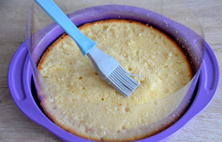 1. Этап. Торт Нежное облако: Снова вложите бисквит в форму, в которой будете собирать торт. Проложите бока ацетатной лентой, кулинарной кистью смажьте корж пропиткой.