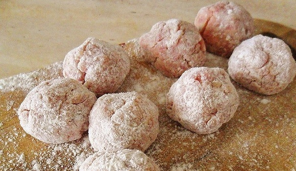 1. Этап. Биточки, запеченные под сметанным соусом: В мисочку насыпьте пшеничную муку высшего сорта. Каждый биточек обмакните в муку так, чтобы она была на всей поверхности мяса. Выложите биточки на разделочную доску.