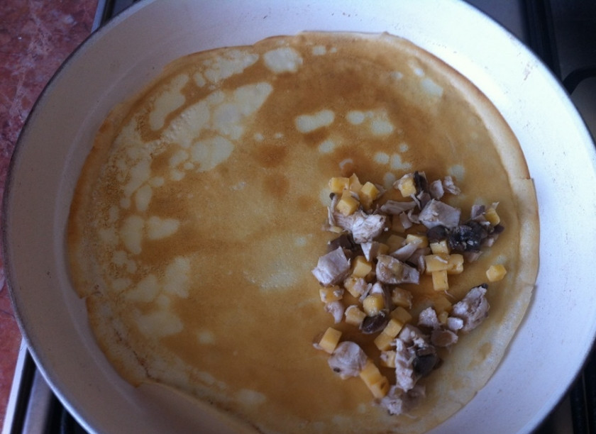 1. Этап. Блинчики с куриной грудкой: Начните обжаривать блины на разогретой сковороде. После того как обжарите одну сторону и перевернете блин, быстро выложите на него часть начинки, прямо на сковороде, чтобы сыр расплавился, и затем заверните готовый блин в трубочку и снимите с огня. Повторите эту операцию, пока не закончится тесто или начинка.