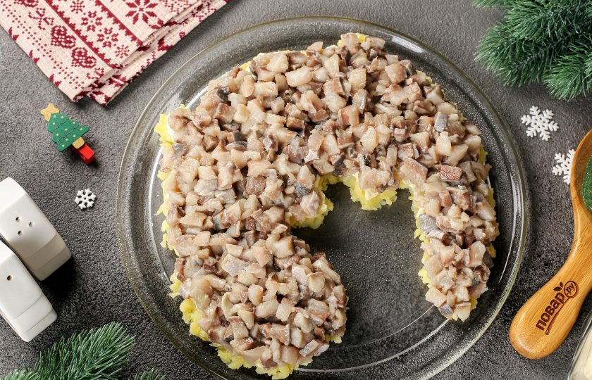 1. Этап. Селедка под шубой на год Дракона: Сверху выложите филе сельди, нарезанное кубиками. Смажьте майонезом.