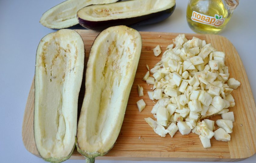 1. Этап. Баклажаны, фаршированные грибами: 2. Баклажаны разрежьте на две части вдоль. Осторожно ножом удалите внутреннюю часть, чтобы получилась лодочка. Слишком тонкие бортики не стоит делать, иначе лодочка не будет держать форму. Посолите хорошо и оставьте лодочки на 20 минут. Мякоть порежьте кубиками.