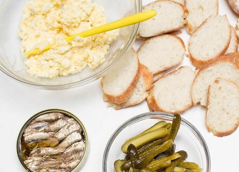 1. Этап. Бутерброды со шпротами и соленым огурцом: Нарезаем ломтиками батон, огурцы нарезаем в зависимости от размера. Если у вас маленькие огурчики, их можно разрезать вдоль. Если крупные — ломтиками поперек.