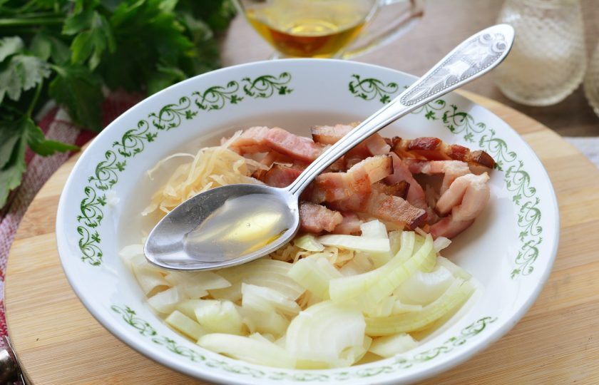 1. Этап. Салат с квашеной капустой и жареным беконом: Полейте салат ароматным маслом, добавьте специи по вкусу и перемешайте.