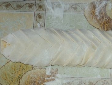 1. Этап. Слоеный сырный пирог: Выкладываем пирог на противень, смазанный растительным маслом. Смазываем его желтком, разведенным с парой ложек холодной воды.