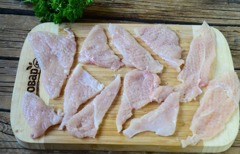 1. Этап. Чипсы из куриного филе: Порежьте каждую отбивную на 2-3 треугольника. Выложите на разделочную доску.