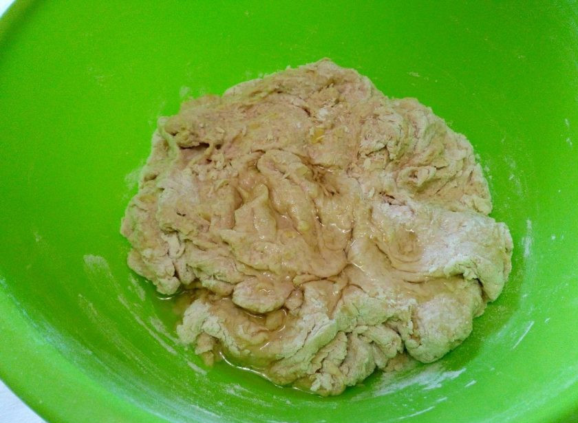 1. Этап. Постные гороховые пирожки: Как только тесто начнёт отставать от стенок миски и собираться в комок, влейте в него подсолнечное масло (2 ст.л.) и завершите замес руками.