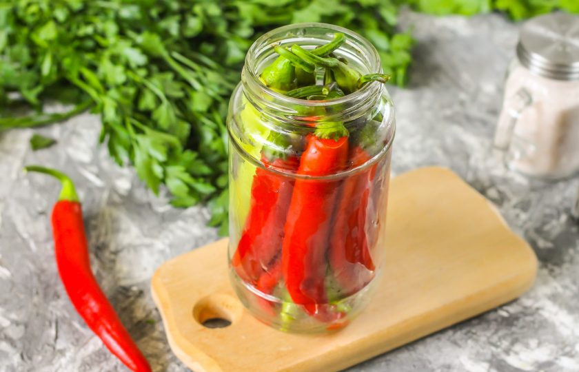 1. Этап. Маринованный горький перец на зиму: Влейте в банку растительное масло, но обязательно рафинированное! Затем влейте горячий маринад до верха.