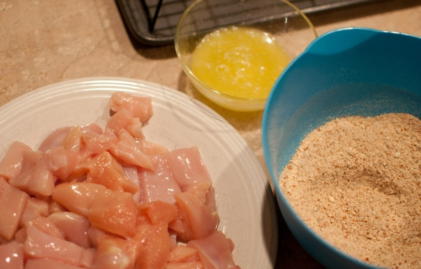 1. Этап. Куриные наггетсы: Слегка взбейте яичные белки. Помойте куриное филе, нарежьте маленькими кусочками. Поставьте чашки с куриным филе, панировочными сухарями и взбитыми белками в таком порядке, в котором вам будет удобно переходить от одного действия к другому.