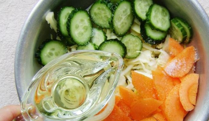 1. Этап. Салат из капусты и огурцов на зиму: Влейте к овощам масло.