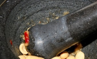 1. Этап. Сом Там: Добавьте сушеные креветки и обжаренный арахис, потолките.