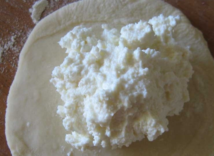 1. Этап. Вареники на кефире: Каждый кружочек еще немного раскатываем и кладем на него любую начинку. Соединяем края теста и формируем аккуратный вареник.