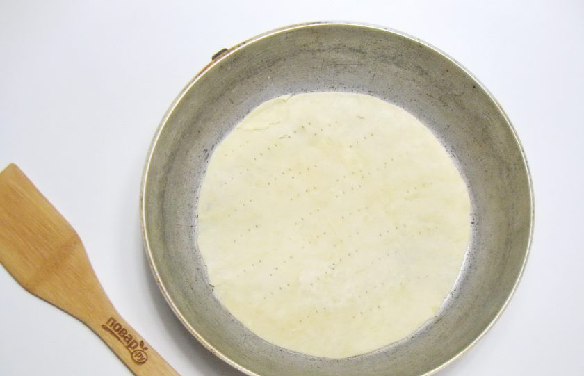 1. Этап. Рубленый торт: Каждый шарик теста раскатайте в пласт. С помощью трафарета или тарелки вырежьте круг. Выложите его в форму для выпекания и наколите вилкой.