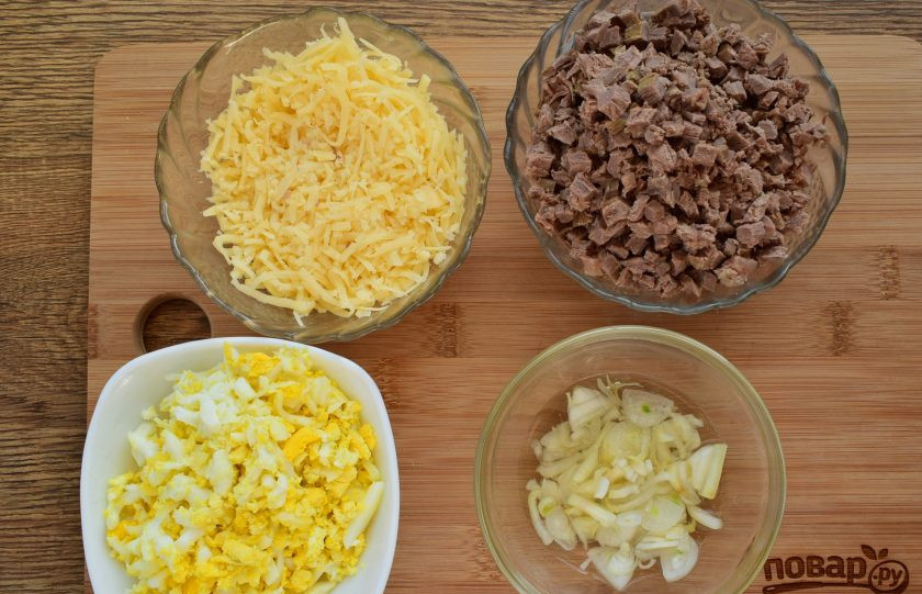 1. Этап. Салат Мужской каприз: Лук нарежьте тонкими колечками (четвертинками), залейте яблочным уксусом и маринуйте в течение 15 минут. Отварную говядину измельчите. Яйца и сыр натрите на крупной терке.