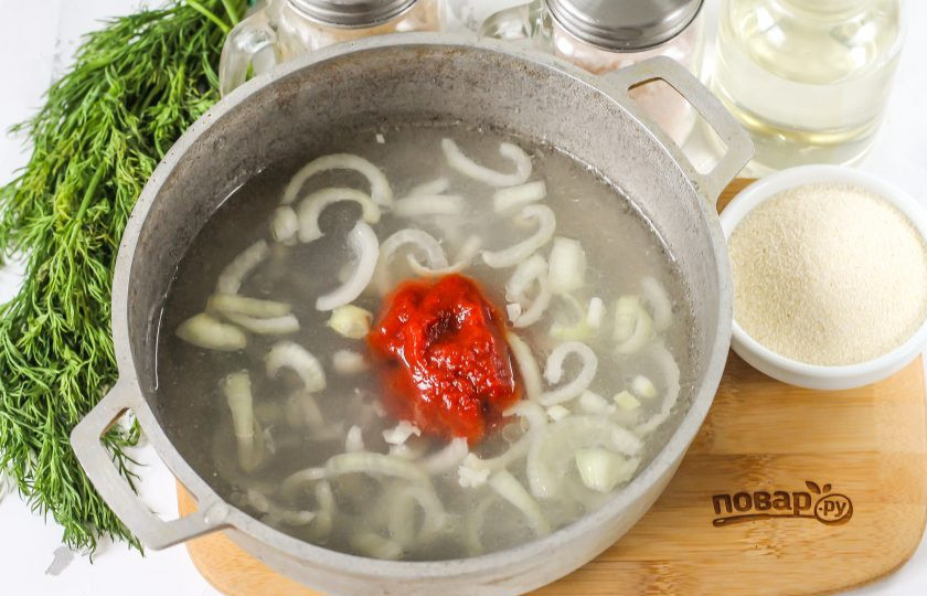 1. Этап. Икра из манки на селедочном рассоле: Влейте в казан теплую воду, рассол, добавьте соль, томатную пасту и растительное масло. По желанию добавьте лавровый лист. Доведите жидкость в казане до кипения.