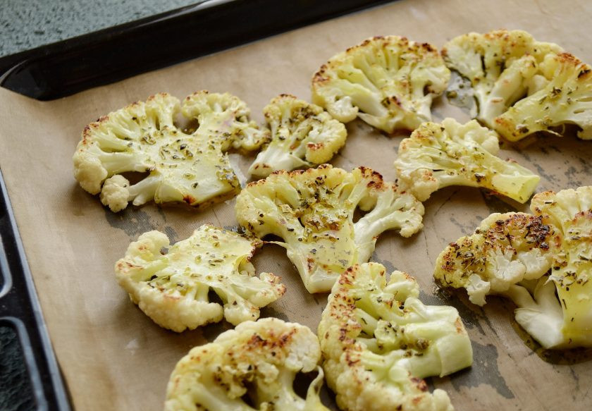 1. Этап. Стейки из цветной капусты: Аккуратно разложите стейки из цветной капусты на противень. Сверху полейте маслом со специями. Запекайте их в духовке 15 минут.