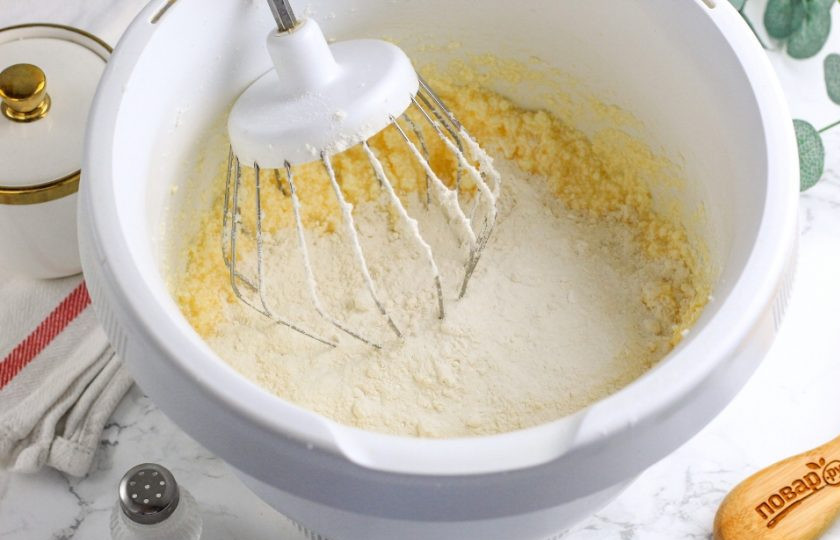 1. Этап. Шоколадно-ванильное печенье: Всыпьте разрыхлитель и пшеничную муку высшего сорта по частям. Просеивать ее не нужно.