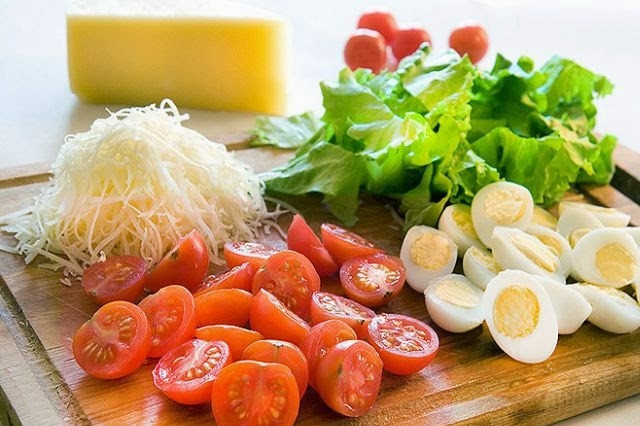 1. Этап. Салат с креветками и яйцом: Сыр натрите на терке, помидоры черри и яйца отварные порежьте на половинки.