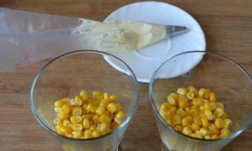 1. Этап. Салат Восторг: Следующим слоем кладём по полной столовой ложке кукурузы, наносим слой майонеза.