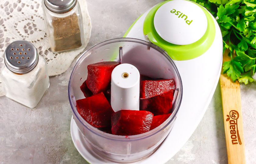 1. Этап. Форшмак со свеклой: Отварную свеклу очистите от кожуры и промойте в воде. Нарежьте средними кубиками и выложите нарезку в емкость измельчителя.