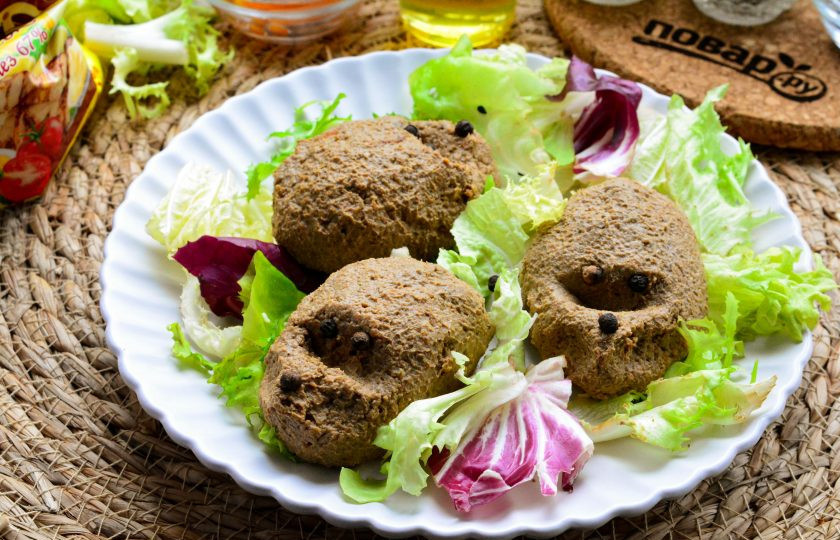 1. Этап. Печеночные ежики: На тарелку выложите салатный микс из зелени. Из паштета слепите колобки с удлиненным носиком, глазки и нос сделайте при помощи черного перца горошком.