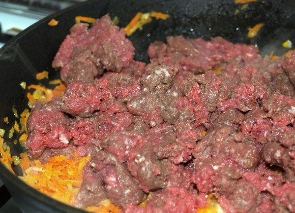 1. Этап. Соус Болоньезе: Лук режем мелко, а морковь натираем на терке. На сковороде растопим сливочное масло, обжарим в нем морковь и лук, затем туда выложим фарш. Жарим все вместе 5 минут.