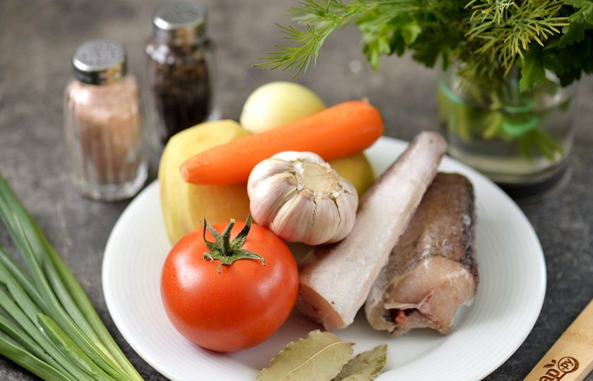 1. Этап. Уха из замороженной рыбы: Подготовьте все ингредиенты. Овощи почистите, помойте. Тушку хека промойте под проточной водой, почистите чешую, сделать это на замороженной рыбе будет легко.