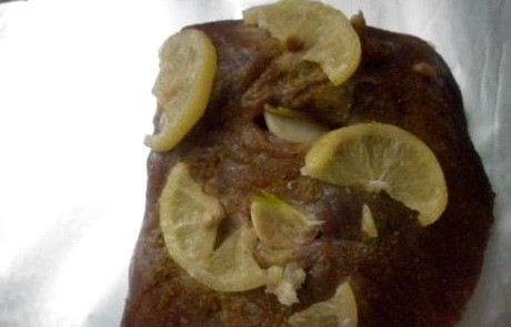 1. Этап. Телятина в мультиварке: По прошествии времени опять достаем мясо, делаем в нем несколько проколов и засовываем в них зубчики чеснока, выкладываем телятину вместе с лимонными дольками на лист фольги.