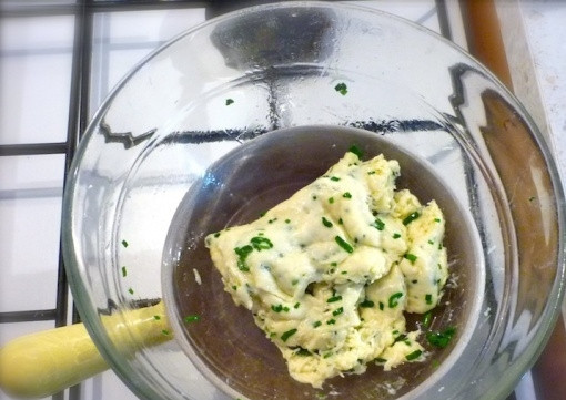 1. Этап. Сырные рулетики с семгой: 4. Подготовьте сырную основу. Для этого используйте водяную баню. На дно посуды меньшего размера уложите зелень и сыр и поставьте на кастрюлю с водой. Постоянно помешивайте смесь венчиком или деревянной палочкой до полного расплавления сыра.