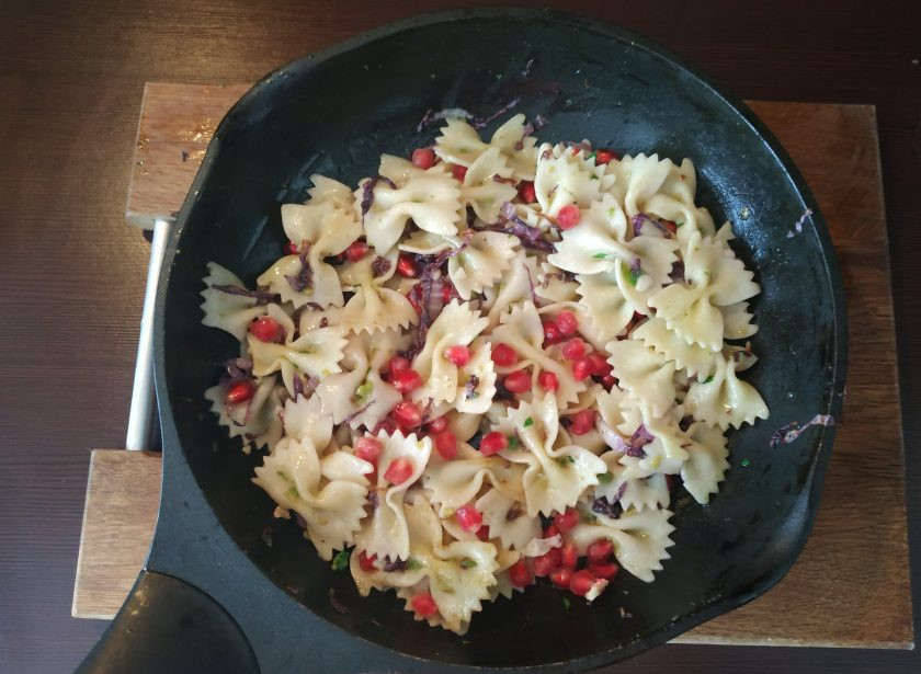 1. Этап. Паста с гранатом: Добавьте зерна граната к макаронам, хорошо все перемешайте и потомите буквально минуту, чтобы ароматы смешались.