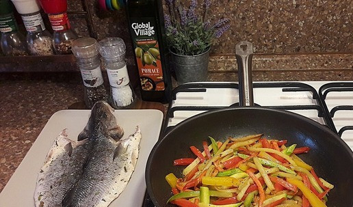 1. Этап. Сочный сибас, запеченный с овощами: Овощи обжарить на сковороде с добавлением масла до состояния «аль денте» в последовательности: сначала картофель, морковь, кабачок, перец. Посолить и поперчить по вкусу. Посыпать рубленной зеленью.