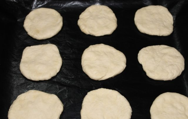 1. Этап. Быстрые мини пиццы: 4. Противень смажьте маслом и разложите маленькие основы для пиццы, придав им форму просто руками.