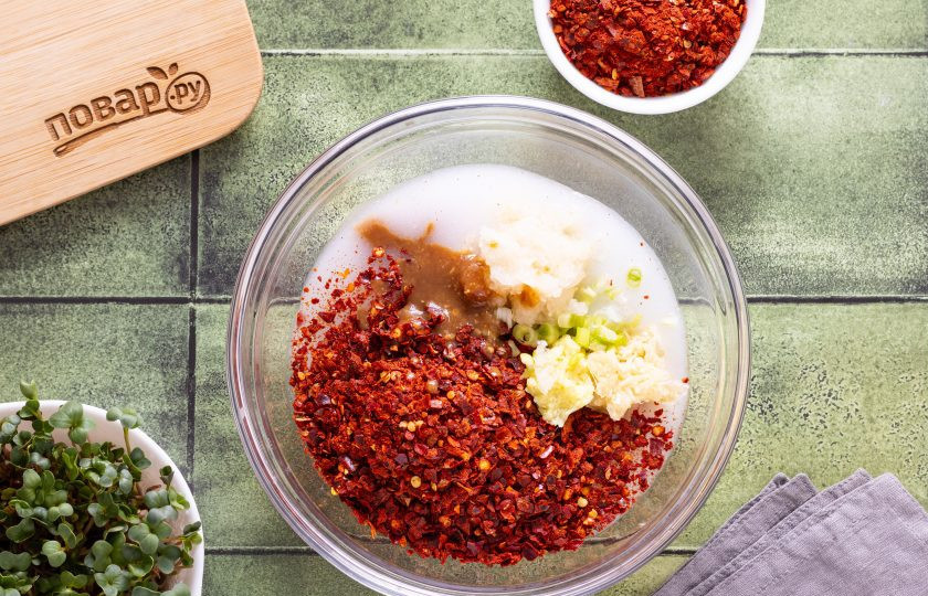 1. Этап. Кимчи из тыквы: Перелейте остывшую основу для заправки в миску. Добавьте очищенную от кожуры и натертую на мелкой терке китайскую грушу, мелко нарезанные белые части зеленого лука, перец кочукару, измельченный чеснок и корень имбиря, мисо-пасту и рыбный соус. Все перемешайте.