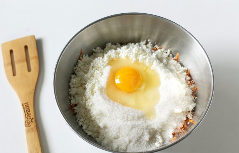 1. Этап. Морковные оладьи с творогом: Добавьте размятый вилкой творог, сахар и яйцо. Если будете подавать оладьи со сладким топпингом, то количество сахара лучше уменьшить.