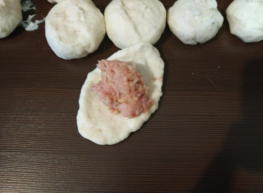 1. Этап. Манты по-корейски: Когда колобки подойдут, разровняйте их руками в кружочки и на центр выложите по ложке начинки. Защипните манты как пироги.