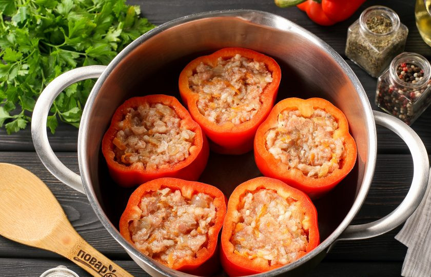 1. Этап. Перцы с фаршем и рисом фаршированные рецепт в кастрюле: Наполните перцы подготовленной начинкой. Выложите их в кастрюлю или в сковороду с высокими краями, можно взять казанок или утятницу. Если у вас остались перцы, можно их заморозить, а если осталось немного фарша, то просто сформируйте тефтельки и выложите их сверху. Они прекрасно приготовятся и у вас получится в прямом смысле два блюда в одном.